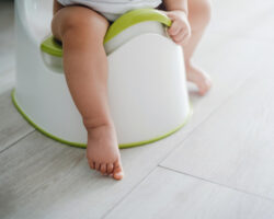 young child using a training potty