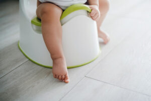 young child using a training potty