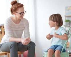 Governess engaging in a conversation with a young child to build confidence and communication skills in a home learning environment.