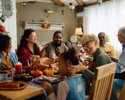 Smiling family celebrating Thanksgiving around a festive dinner table, enjoying a relaxed and organized holiday