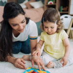 Nanny and a little girl spending time together at home.