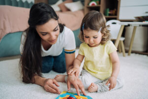 Nanny and a little girl spending time together at home.